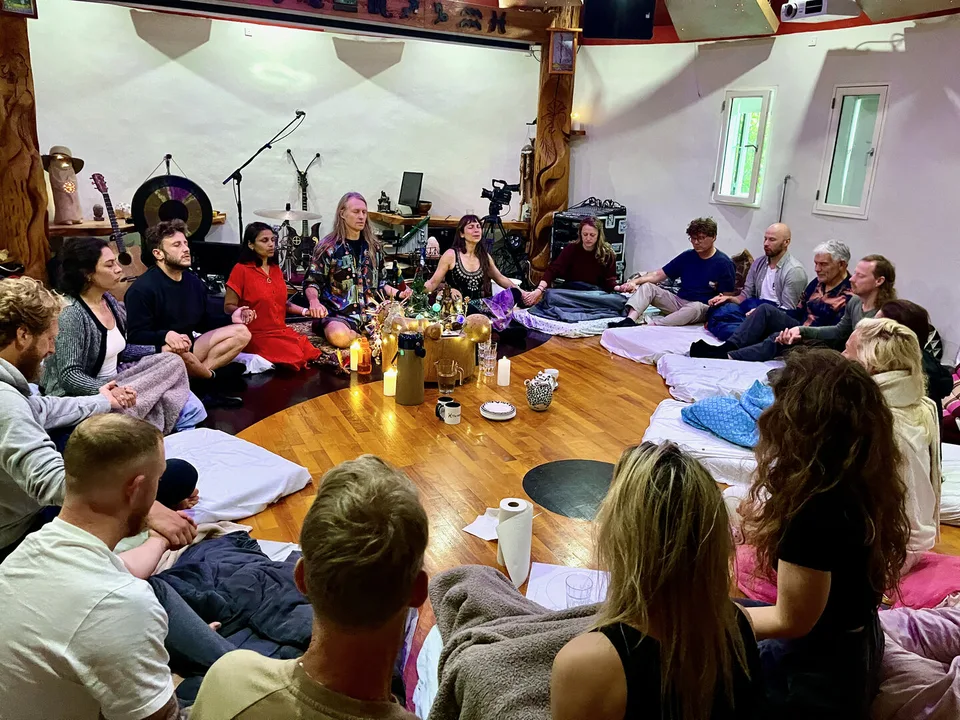 Delecirkel efter ayahuasca-ceremonien: Jacob og Ecaterina sidder i midten af en cirkel af deltagere på gulvet i Rundsalen, med stearinlys og te i midten