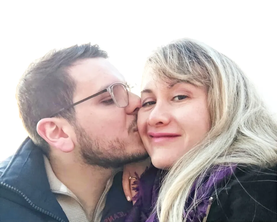 Catherine og hendes forlovede: han kysser hende på kinden, hun smiler, og forlovelsesringen ses på hendes hånd.