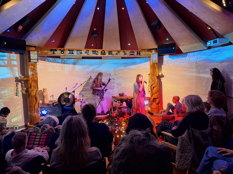 Rundsalen under en fuldmånekoncert: Jacob og Ecaterina spiller på scenen under stjernehimlen i loftet og bjælken med de tolv stjernetegn, og gæsterne sidder og lytter