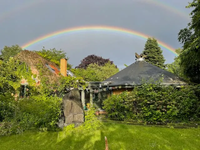 A rainbow over the roof of the Roundhall and the green garden after rain