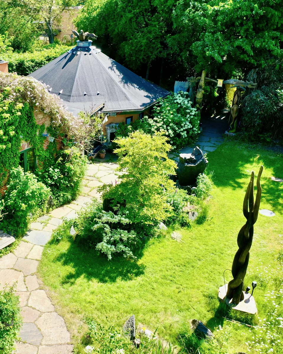 Stien gennem den grønne have mod Rundsalen, hvor ayahuasca-retreatet foregår, set ovenfra en sommerdag
