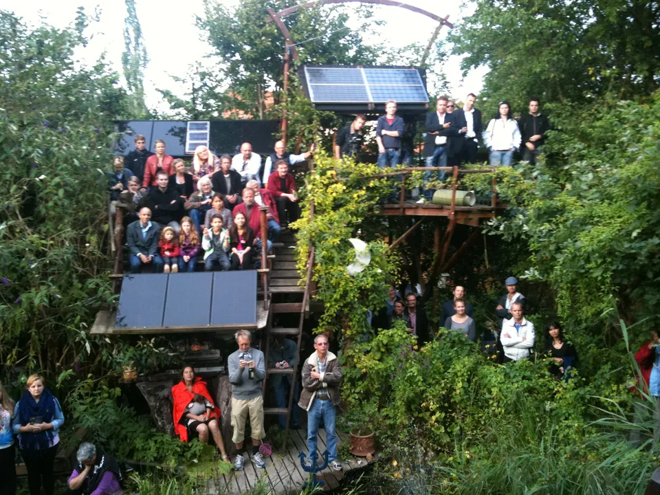 Many people standing close together on the hand-built stand in the garden at The Magic Garden one evening in September 2010